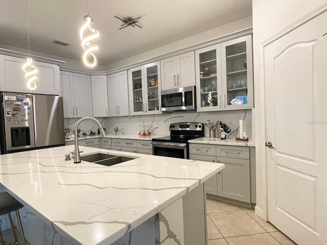 1574 Thetford Cir, Orlando, FL 32824 - kitchen featuring appliances with stainless steel finishes, a sink, light stone countertops, and gray cabinetry