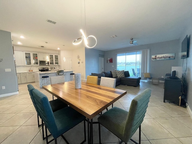 1574 Thetford Cir, Orlando, FL 32824 - dining room with light tile patterned floors, a ceiling fan, and baseboards