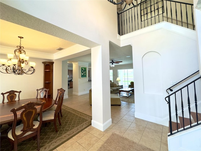 dining room featuring light tile patterned floors, baseboards, visible vents, ceiling fan with notable chandelier, and stairway