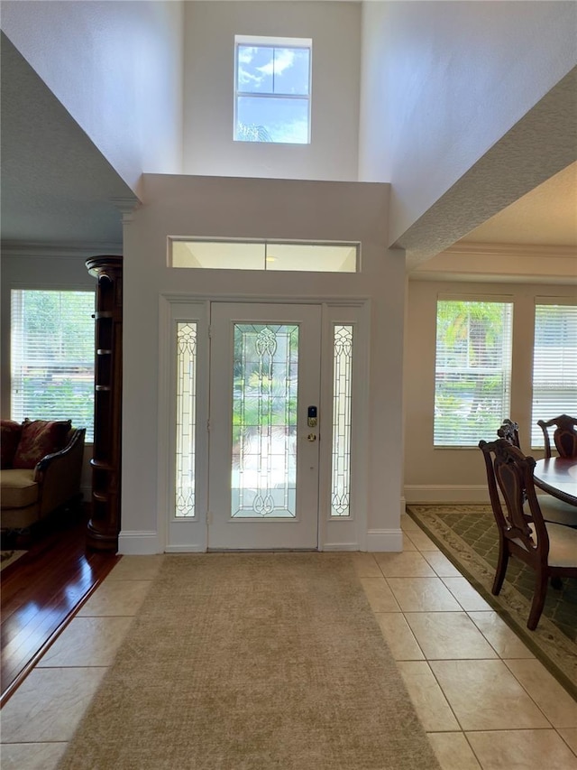 entryway with a wealth of natural light and light tile patterned floors