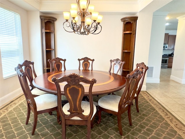dining room featuring an inviting chandelier, tile patterned flooring, baseboards, and ornamental molding