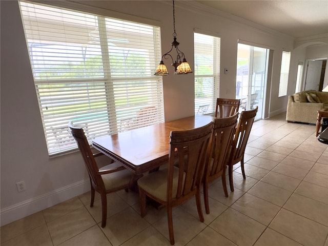dining space with light tile patterned floors, a chandelier, baseboards, and ornamental molding