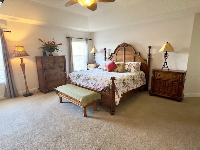 bedroom featuring baseboards, a tray ceiling, ceiling fan, and carpet floors