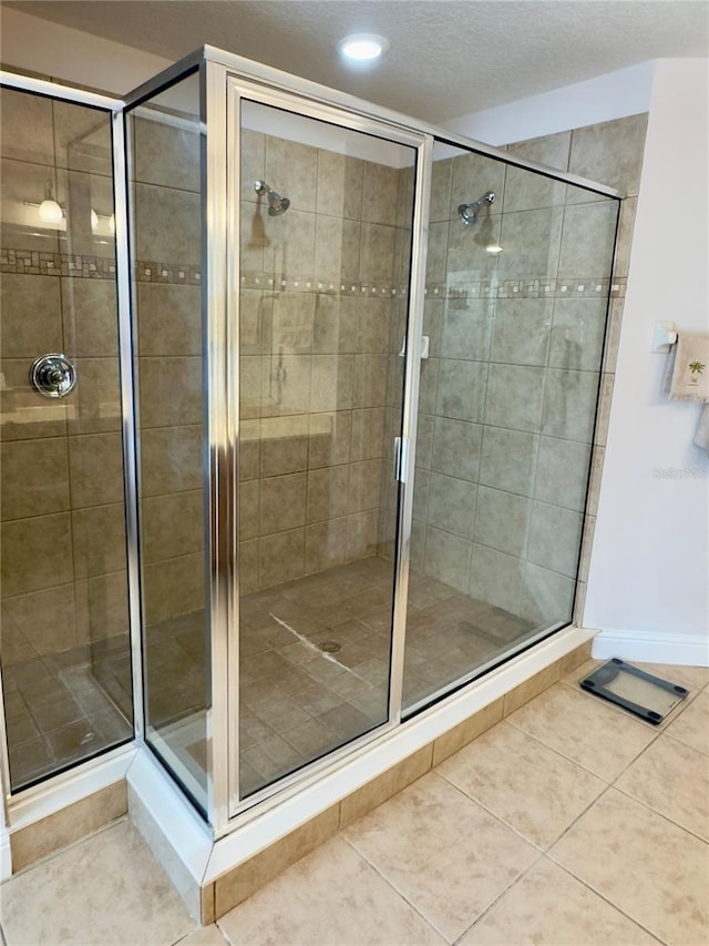 bathroom featuring tile patterned flooring, baseboards, and a shower stall