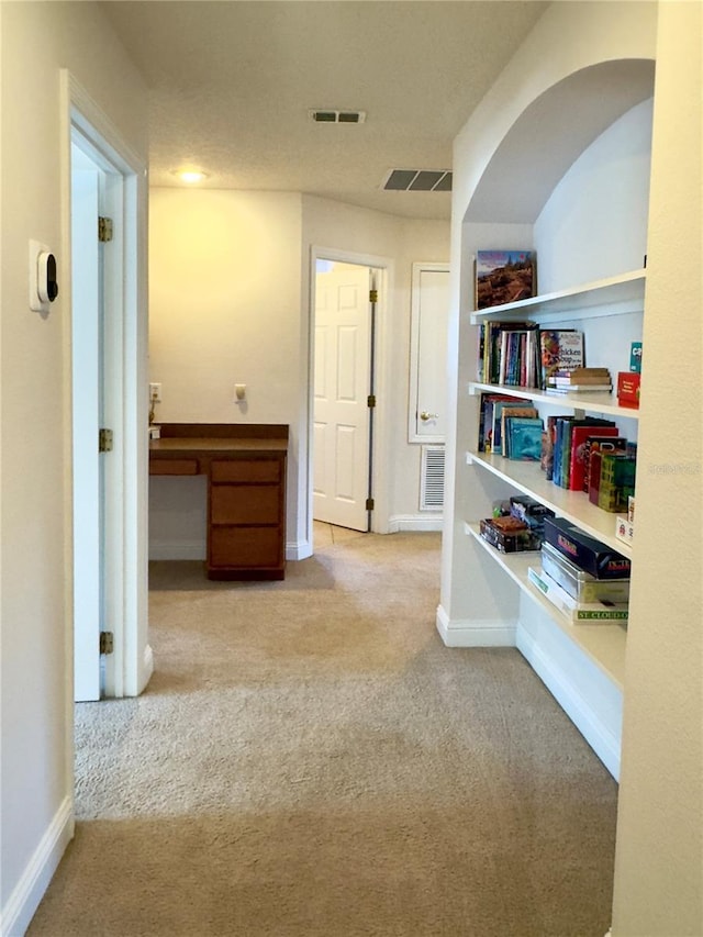 corridor featuring baseboards, visible vents, and carpet floors