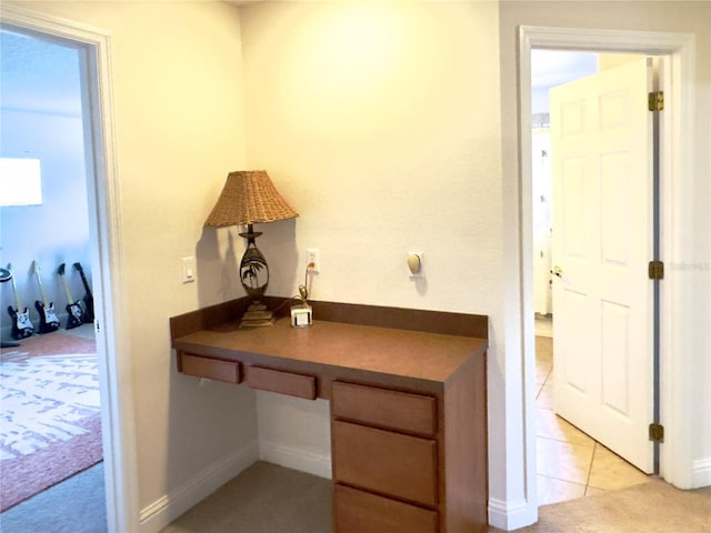 home office with built in desk, baseboards, and light tile patterned floors