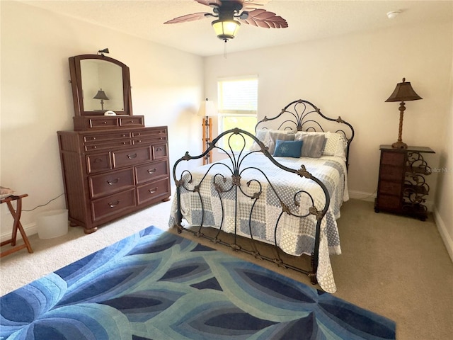 bedroom featuring baseboards, light carpet, and ceiling fan