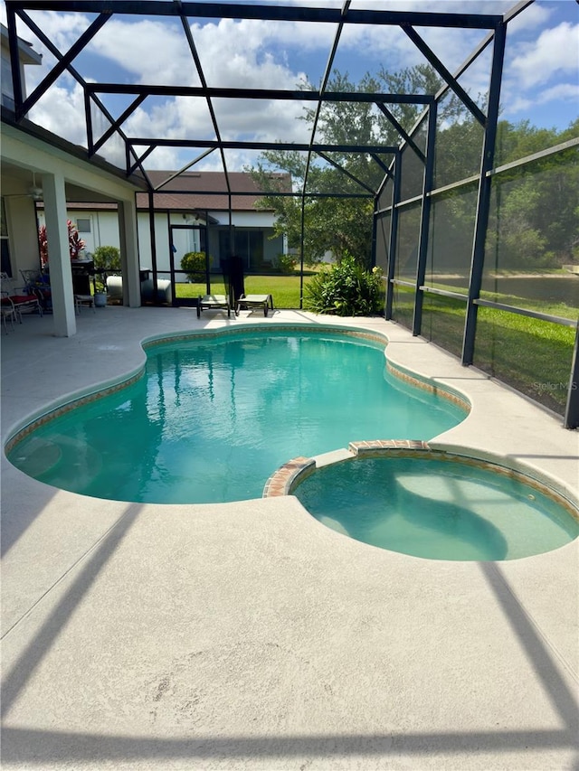 view of pool featuring a patio, a pool with connected hot tub, and glass enclosure