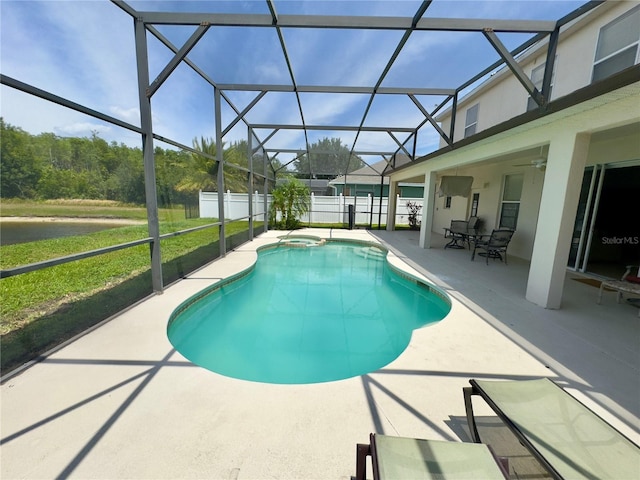 view of swimming pool with a patio area, a pool with connected hot tub, fence, and glass enclosure