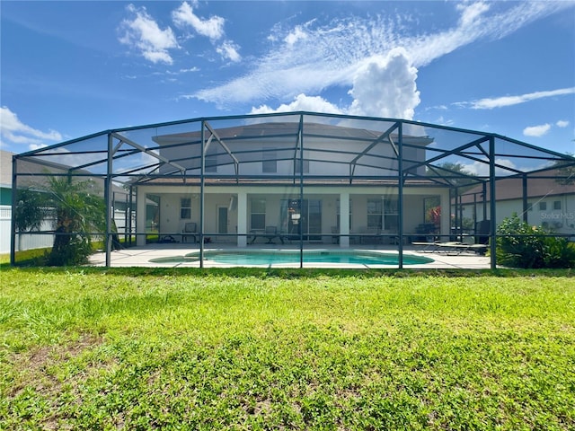 rear view of property featuring a lawn, a patio area, and an outdoor pool