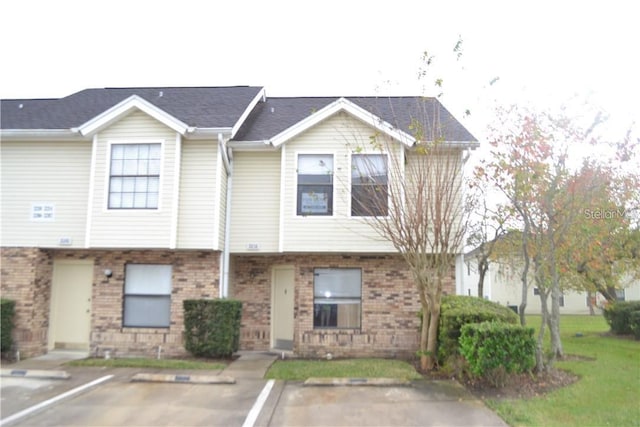 multi unit property featuring brick siding and uncovered parking