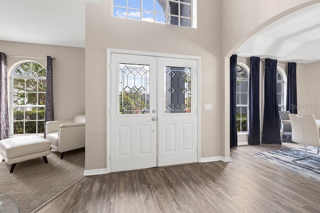 13044 Lakeshore Grove Dr, Winter Garden, FL 34787 - entryway with wood finished floors, arched walkways, baseboards, and a towering ceiling