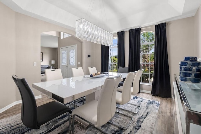 13044 Lakeshore Grove Dr, Winter Garden, FL 34787 - dining room featuring arched walkways, light wood finished floors, a chandelier, and baseboards