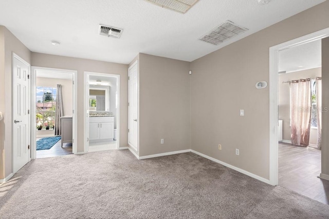 13044 Lakeshore Grove Dr, Winter Garden, FL 34787 - unfurnished bedroom featuring light colored carpet, baseboards, and connected bathroom