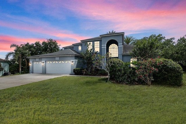 13044 Lakeshore Grove Dr, Winter Garden, FL 34787 - view of front facade featuring driveway, stucco siding, an attached garage, and a lawn