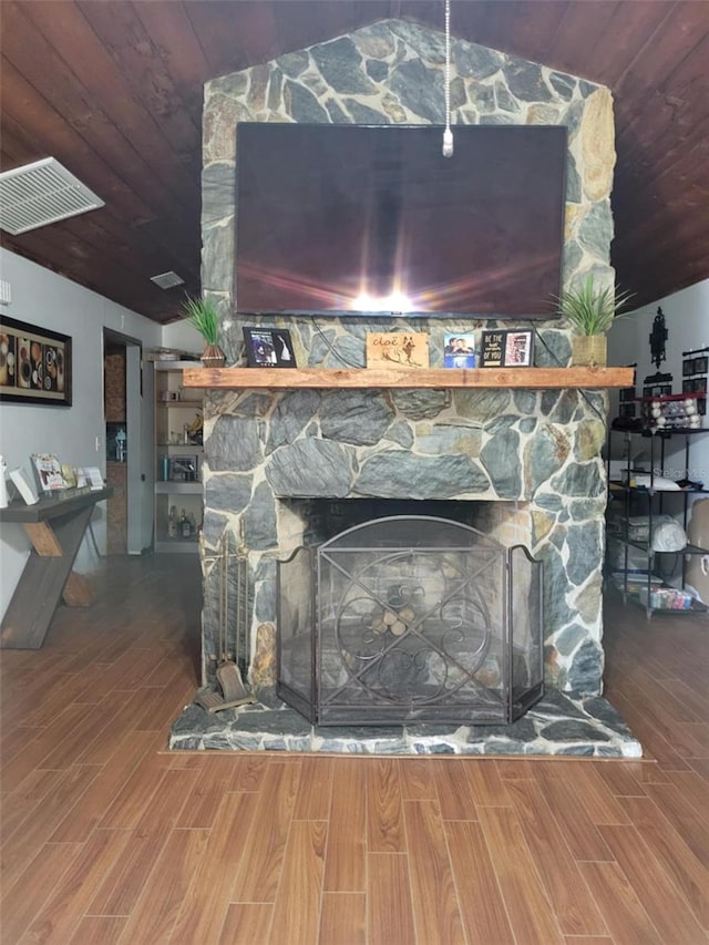 interior details with visible vents, a fireplace, wood finished floors, and wooden ceiling