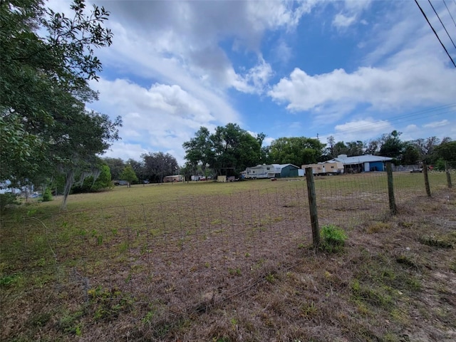 view of yard featuring fence and a rural view