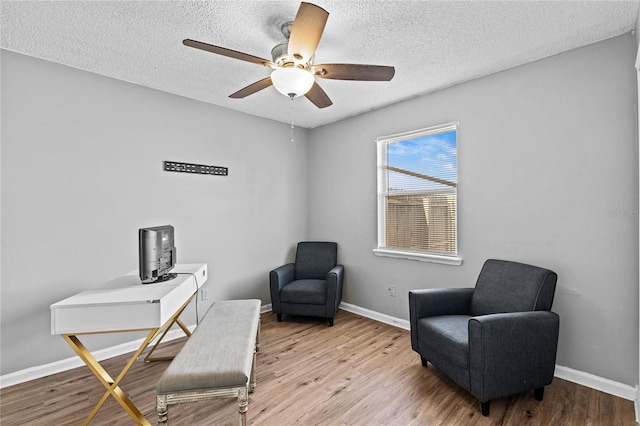 office featuring baseboards, a ceiling fan, a textured ceiling, and wood finished floors