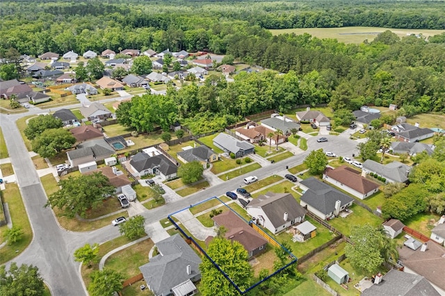 birds eye view of property featuring a residential view and a wooded view