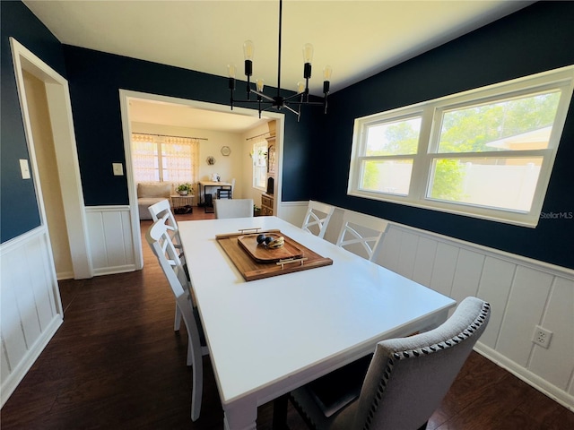 1419 Ave D NE, Winter Haven, FL 33881 - dining room featuring a chandelier, a wainscoted wall, a decorative wall, and dark wood-style flooring