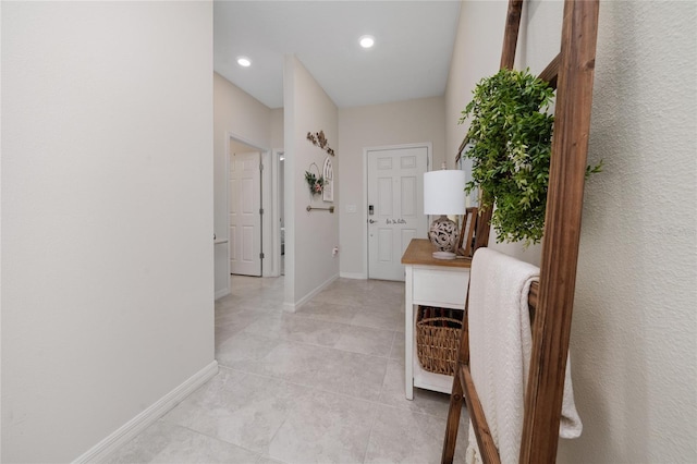 corridor featuring light tile patterned floors, baseboards, and recessed lighting