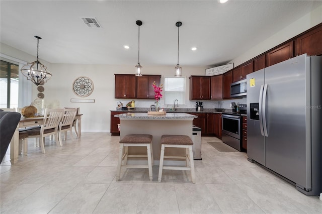kitchen featuring a sink, visible vents, pendant lighting, a center island, and appliances with stainless steel finishes
