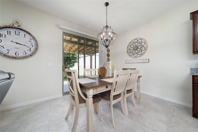 dining space featuring baseboards, an inviting chandelier, and light tile patterned floors