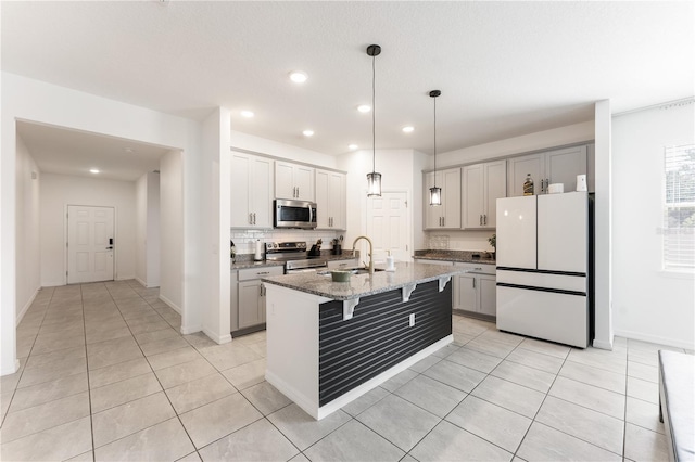 kitchen featuring recessed lighting, a breakfast bar, a sink, backsplash, and appliances with stainless steel finishes