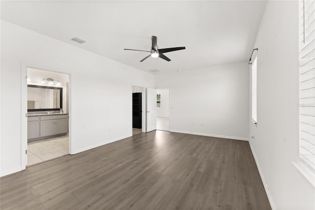 interior space with ceiling fan, visible vents, and wood finished floors