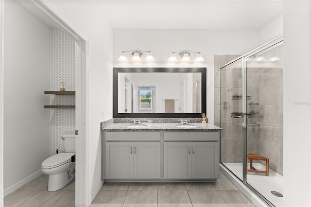 bathroom with a sink, double vanity, toilet, and a stall shower