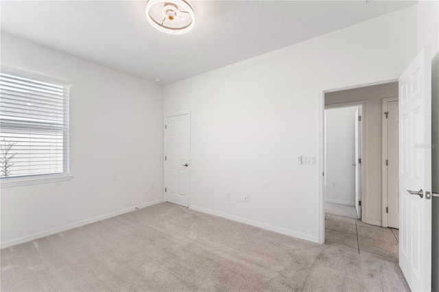 carpeted empty room featuring baseboards