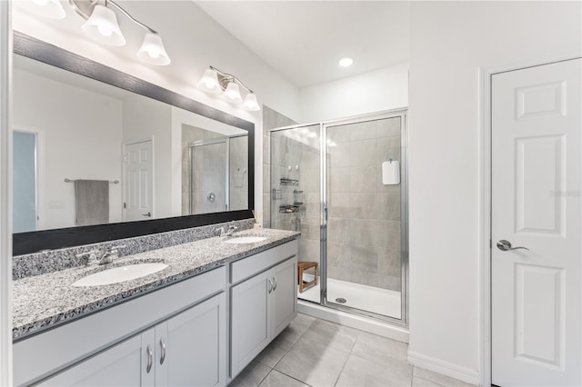 full bath featuring a sink, tile patterned flooring, double vanity, and a stall shower