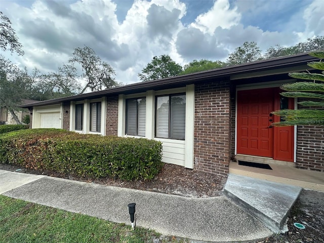 view of side of home featuring brick siding and a garage