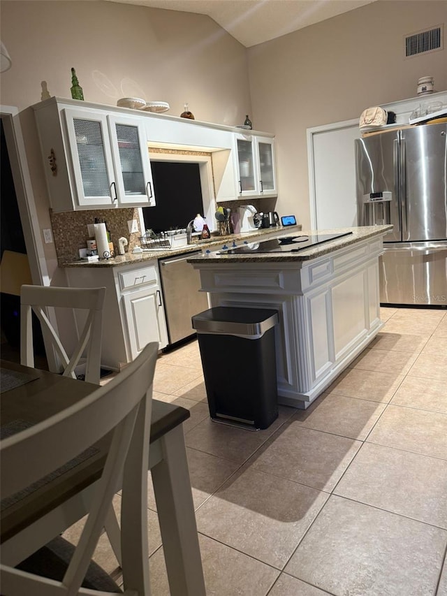 kitchen featuring light tile patterned floors, a center island, white cabinetry, visible vents, and appliances with stainless steel finishes