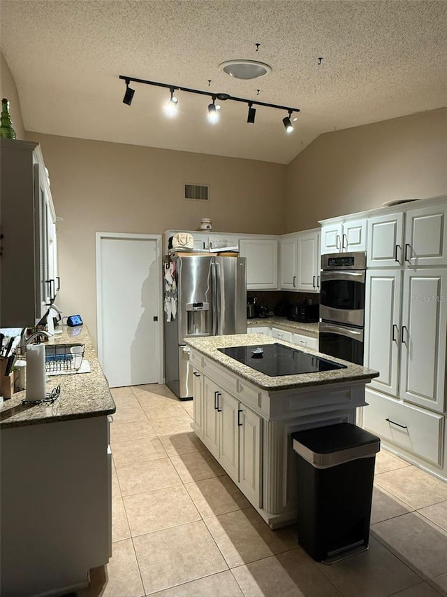 kitchen with track lighting, appliances with stainless steel finishes, visible vents, and light tile patterned floors