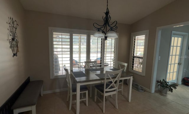 dining area with vaulted ceiling, a chandelier, a wealth of natural light, and light tile patterned floors
