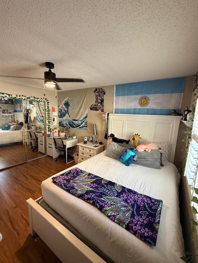 bedroom featuring a textured ceiling, wood finished floors, and ceiling fan