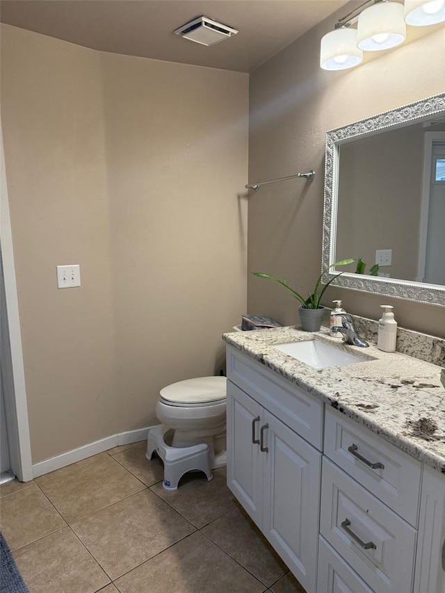 bathroom featuring toilet, tile patterned flooring, vanity, and baseboards