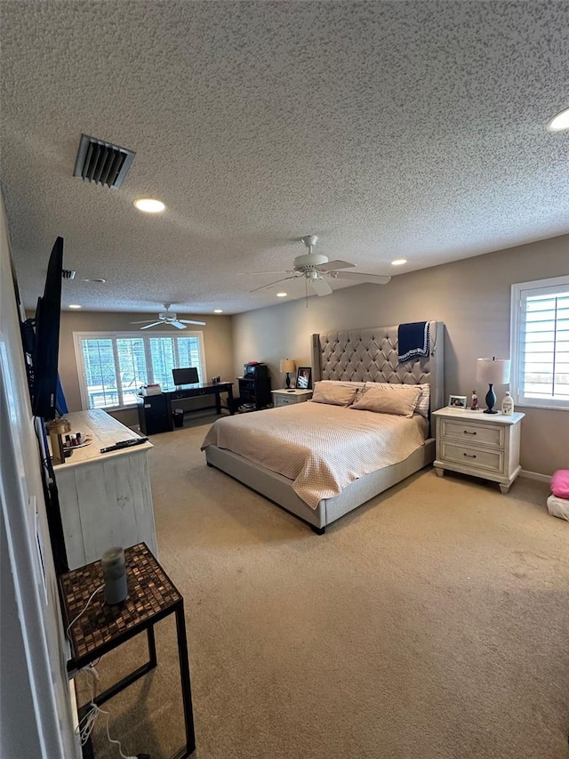 bedroom featuring light colored carpet, a textured ceiling, visible vents, and recessed lighting