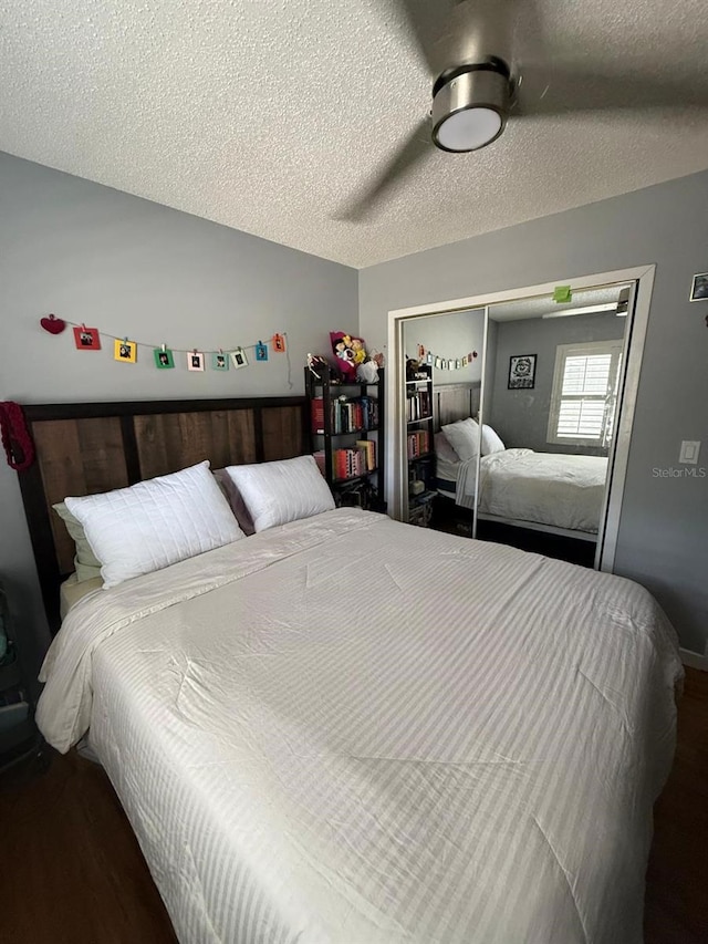 bedroom featuring a ceiling fan, a closet, a textured ceiling, and wood finished floors