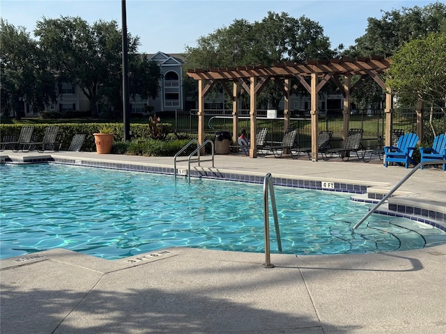 community pool featuring a patio, a pergola, and fence