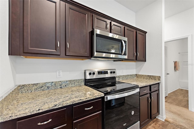 5816 Beefmaster Rd, Saint Cloud, FL 34771 - kitchen with stainless steel appliances, dark brown cabinets, and light stone counters