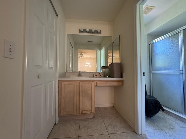 bathroom featuring a shower with door, a closet, visible vents, tile patterned flooring, and vanity