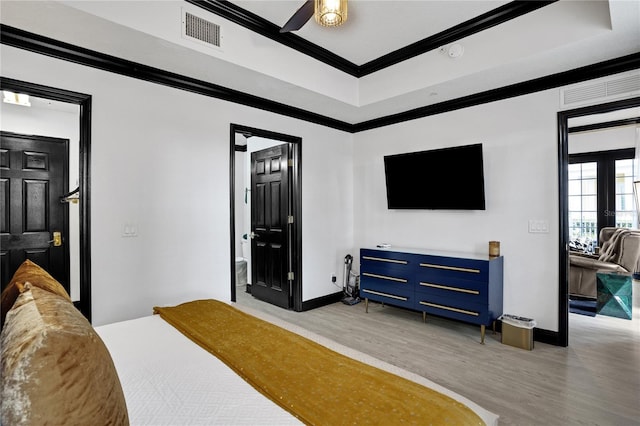 bedroom featuring light wood finished floors, visible vents, baseboards, and ornamental molding