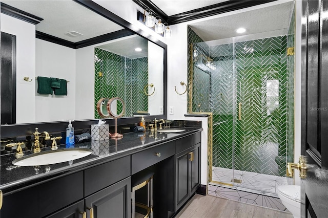 bathroom featuring a sink, crown molding, toilet, and a stall shower