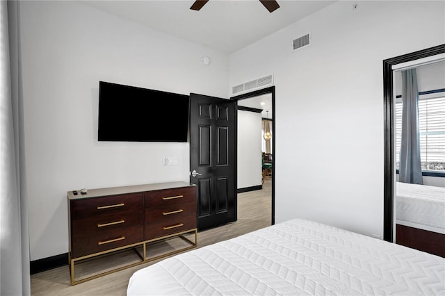 bedroom featuring ceiling fan, baseboards, light wood-type flooring, and visible vents