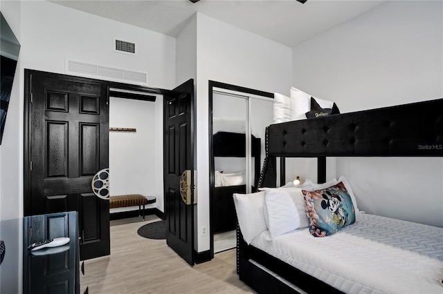 bedroom with light wood-type flooring and visible vents