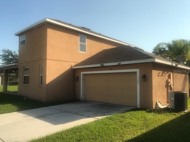 3102 Westbrook Rd, Kissimmee, FL 34746 - view of side of property with concrete driveway, stucco siding, a lawn, and central AC
