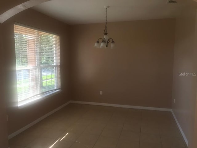 3102 Westbrook Rd, Kissimmee, FL 34746 - empty room featuring arched walkways, a notable chandelier, light tile patterned flooring, and baseboards