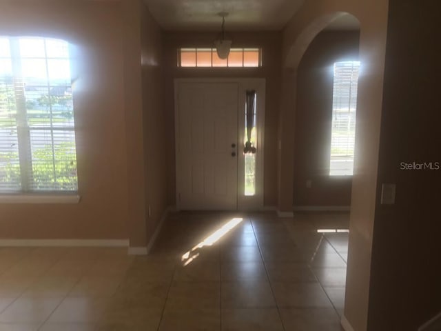 3102 Westbrook Rd, Kissimmee, FL 34746 - entrance foyer with arched walkways, tile patterned flooring, a healthy amount of sunlight, and baseboards